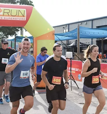 Halloween fun run at 3 Daughters Brewing featuring a group of racers on the road.