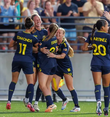 women professional soccer players from the Tampa Bay Sun Football Club celebrate a win on the field. Photo credit: Mike Carlson