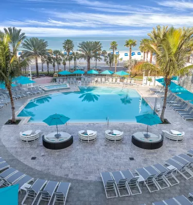 Aerial view of an outdoor hotel pool on the beach.