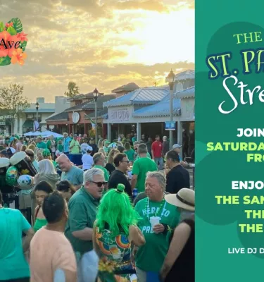 Groups of people dressed up in green at an outdoor St. Patrick's Day festival.