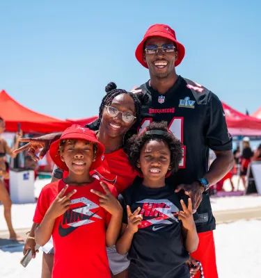 A family poses infront of a camera at Bucs Beach Bash
