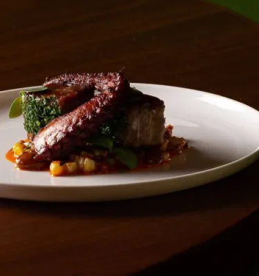 Flavors of Spain event featuring a Spanish meat dish on a white plate.