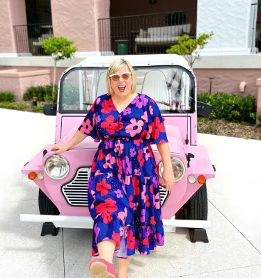 woman standing in front of pink car