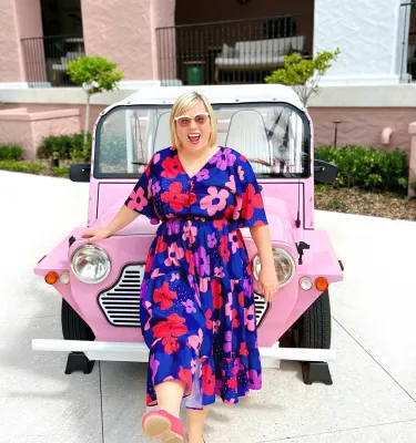 woman standing in front of pink car