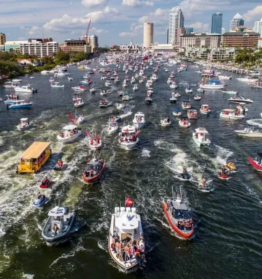 Patriotic boat parade on the river in downtown Tampa featuring hundreds of boats sailing in the water.