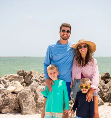 family standing on the beach