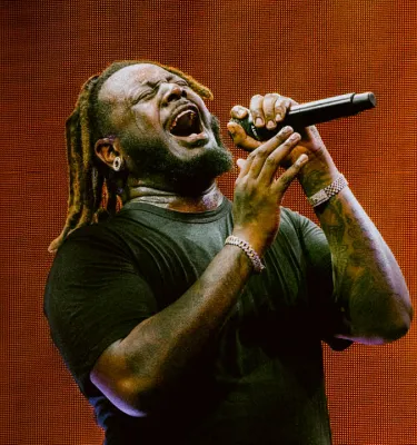 Artist T-Pain singing into a microphone.