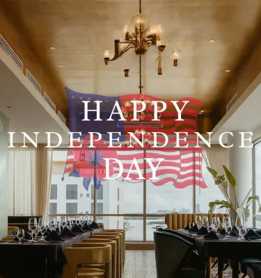 An interior photo of the Ocean Seven restaurant at the Hiatus Hotel with "Happy Independence Day" and American flag overlay