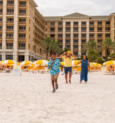 a family on the beach in front of the Sandpearl Resort in Clearwater Beach