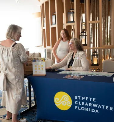 Woman at the desk of a Visit St. Pete-Clearwater Booth