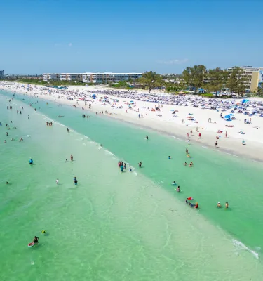 drone shot of the beach with emerald water