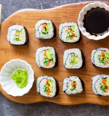 Sushi rolls on a wooden plate.