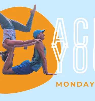 Acro Yoga Class featuring two yoga instructors doing a joint hold position.