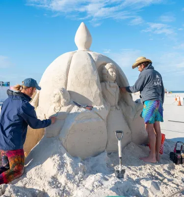 two people working on a sand sculpture at Sanding Ovations Master's Cup