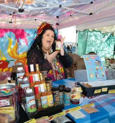 Saucy Queen, a vendor at Shopapalooza in St. Pete, holding up a jar of sauce