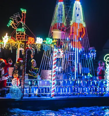 a boat decorated in holiday lights for a boat parade