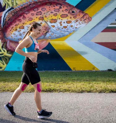 runner going past a colorful fish mural at the St. Petersburg Distance Classic