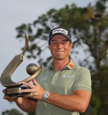 Viktor Hovland holds the winner trophy at PGA Tour's Valspar Championship