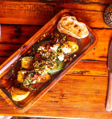 a beautiful plate of food on a rustic wooden table at Calida Kitchen + Wine in St. Petersburg