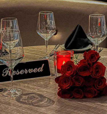 Valentine's Day Dinner featuring a reserved table with wine glasses and red roses.
