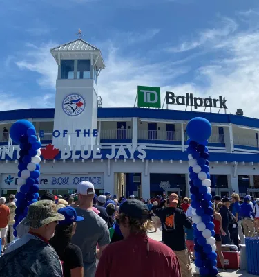 a crowd gathers at the gates of TD Ballpark for a Blue Jays spring training games