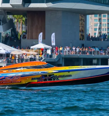 A powerboat speeds past a crowd of fans at the St. Pete Pier on a sunny day in St. Pete, Florida.
