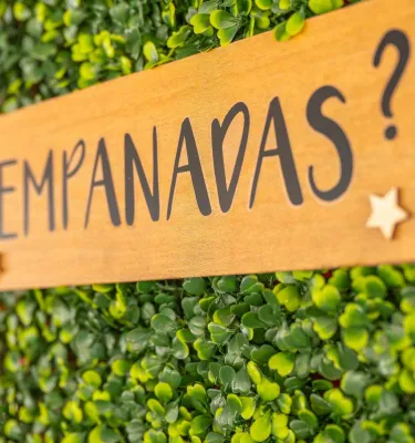 a wooden sign that says "empanadas?" on a green background