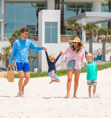 a couple with two young boys walks from Opal Sands out onto Clearwater Beach