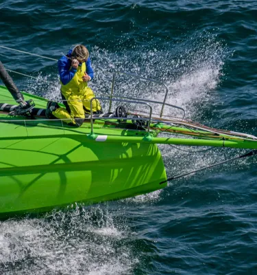 a person at the bow of a bright green sailboat during The Ocean Race, which will come to St. Pete-Clearwater in May 2027