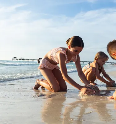 three kids play in the sand on Clearwater Beach