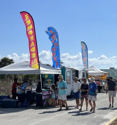 Outside festival featuring people walking around and looking at vendor tents.
