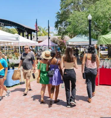 Dunedin Main St Market featuring people walking around and shopping vendor tents.