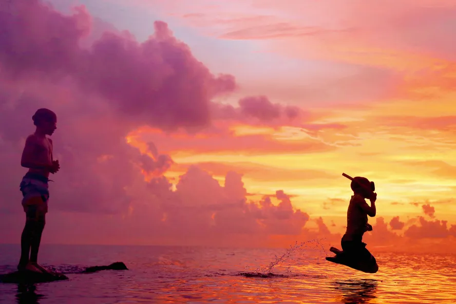 Snorkeler jumping into the Gulf of Mexico during a beautiful sunset in Honeymoon Island.
