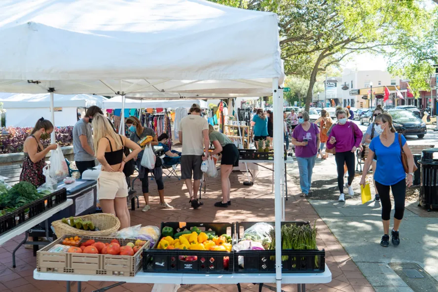 Pessoas procuram produtos em um estande no Safety Harbor's Market on Main.