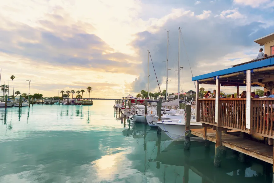 The soft light of sunset is seen over the water and dock at the Dunedin Marina
