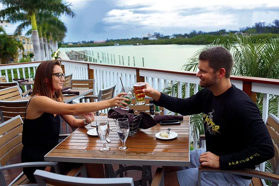 A couple toasts at a outdoor table at Salt Rock Grill