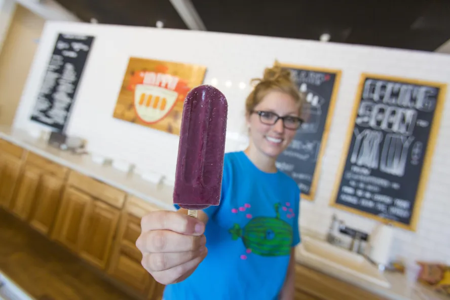 A woman holds up a popsicle at Hyppo gourmet ice pops