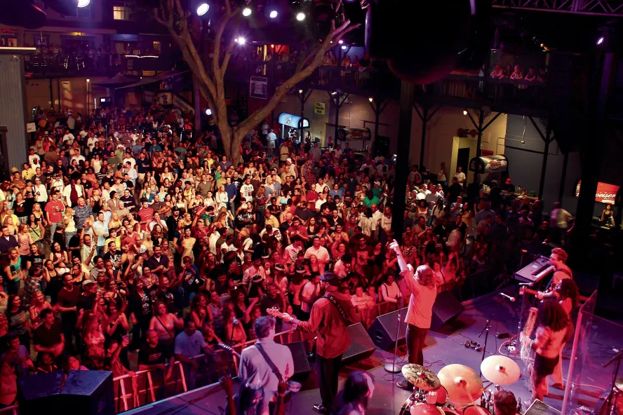 A band plays in front of a tightly packed crowd of people at Jannus Live