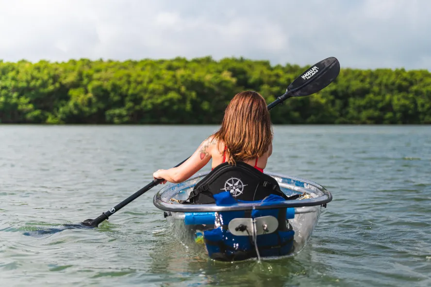 A woman kayaks in a see-through kayak on St. Pete/Clearwater waterways