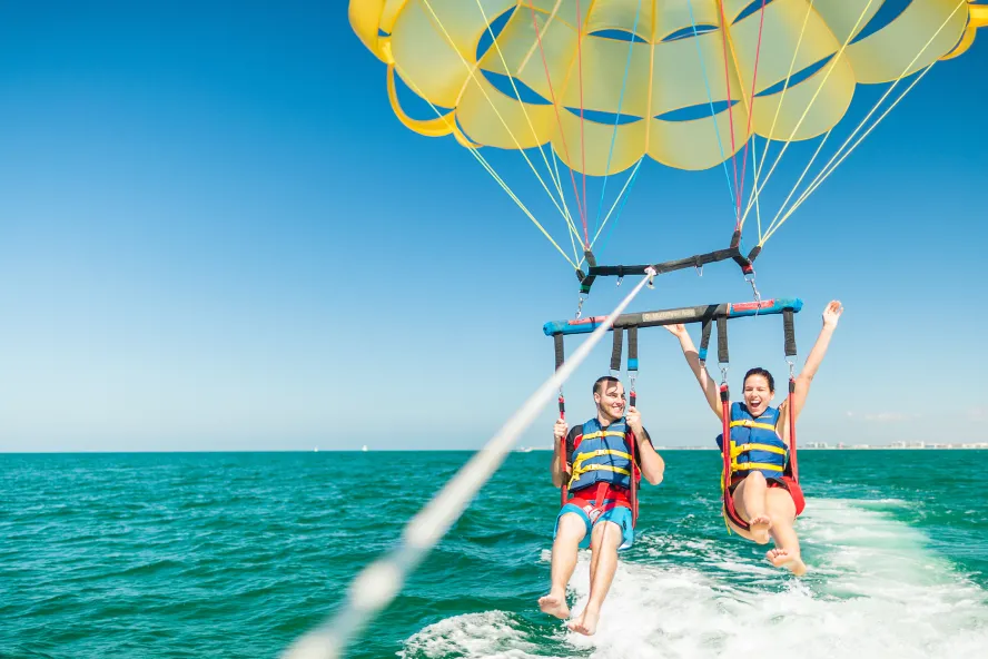 A couple taking flight in a parasail in Clearwater Beach.