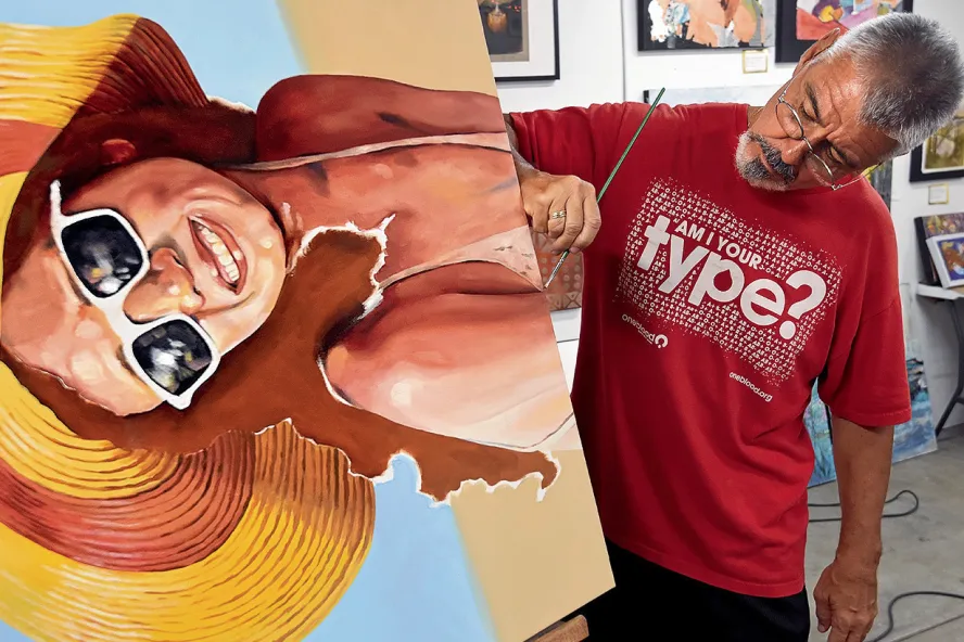 Der Maler Bob Ribits arbeitet in den Soft Water Studios im Warehouse Arts District und vollendet ein Gemälde einer Dame in Badeanzug, Sonnenbrille und Strandhut.