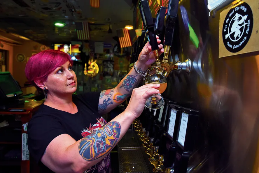 A bartender pours beer at the Ale & The Witch