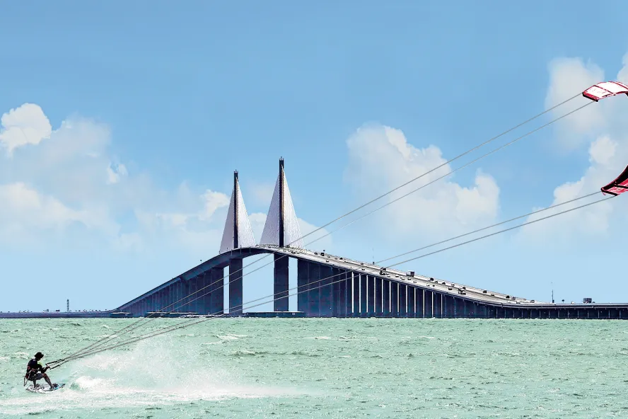 A man kiteboards at the Skyway Bridge