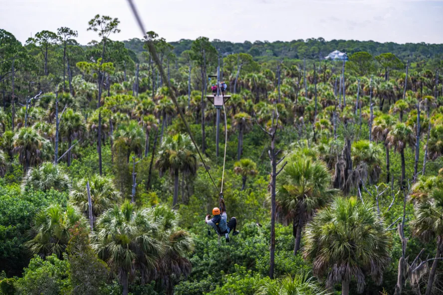 A person rides the zipline at Empower Adventures