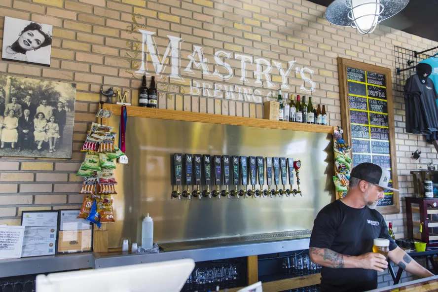 A bartender holding a beer glass at Mastry's Brewing Co. in St. Pete Beach.