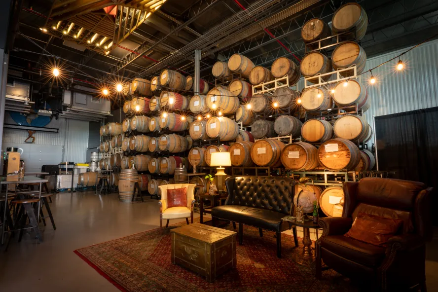 The interior of Webb City Cellar brewery showing a leather couch and several barrels.