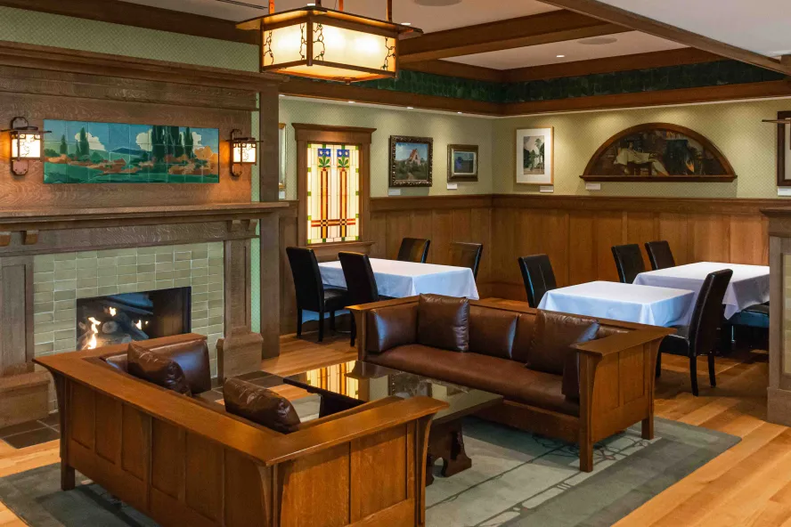 A restaurant dining room featuring wooden furniture, stained glass and hand-painted tiles.