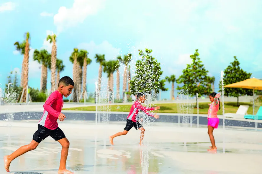 Two boys and a girl play at the splash pad at the St. Pete Pier