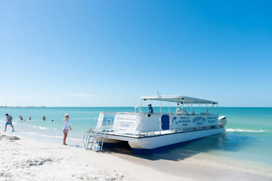a pontoon boat used for dolphin tours beached on St. Pete Beach