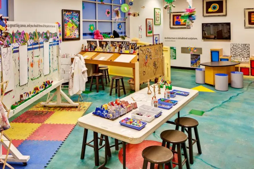 a children's art area with colorful tables and activities at the Morean Arts Center